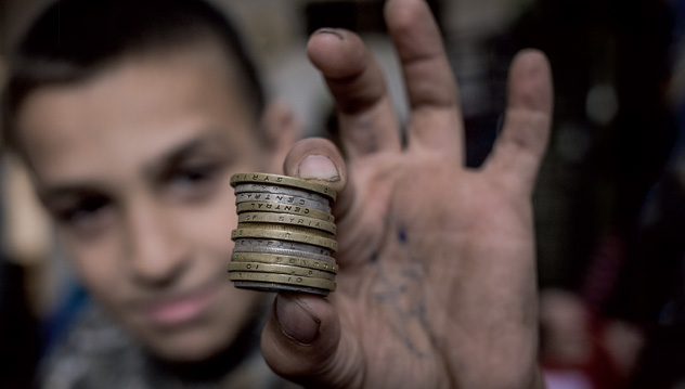 À Amman, un jeune réfugié exhibe quelques pièces de monnaie syriennes, maigres souvenirs de son pays. Photo : Valérian Mazataud