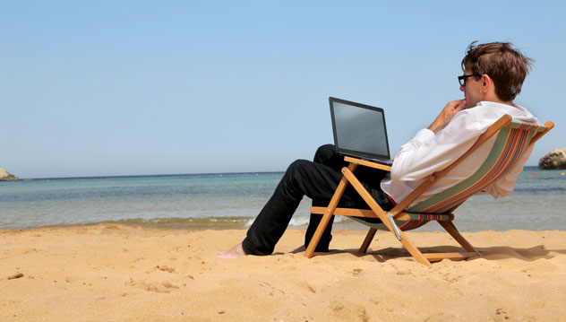 Travailleur sur son ordinateur à la plage